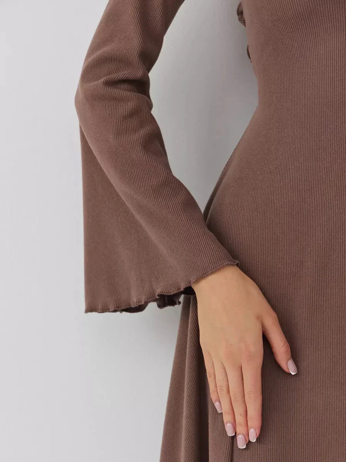 Close-up of a flared cuff sleeve on a stylish brown mini dress, showcasing ribbed texture and elegant design.