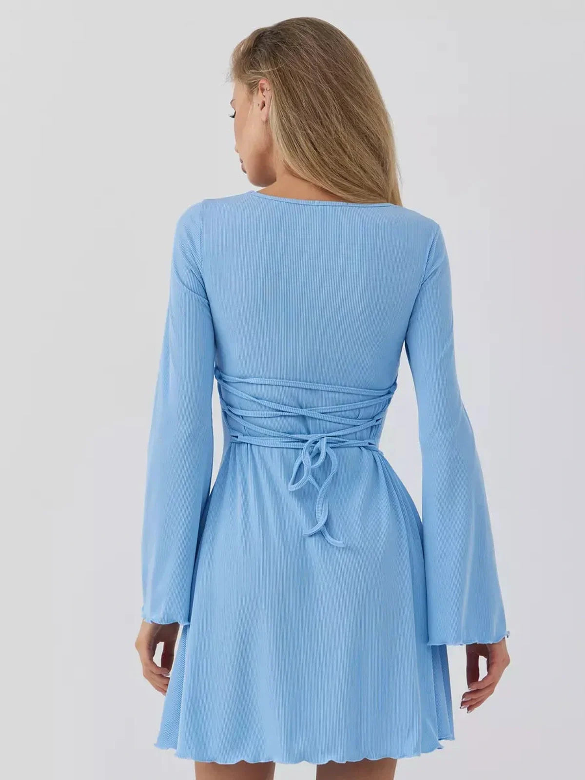 Back view of the Skyline Cutout mini dress in sky blue, featuring bell sleeves and a ruched waist design.