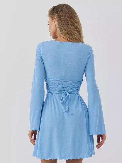 Back view of the Skyline Cutout mini dress in sky blue, featuring bell sleeves and a ruched waist design.