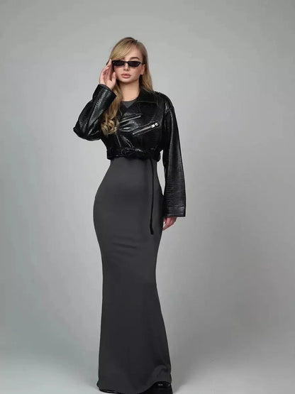 Model showcasing the Sculpted Grace Maxi Dress, featuring a sleek silhouette with long sleeves and stylish accessories.