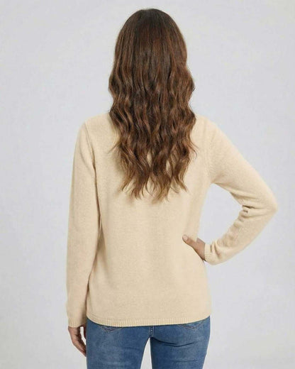 Back view of a woman wearing the Lauven Monaco Sweater in beige, featuring a classic knit design.