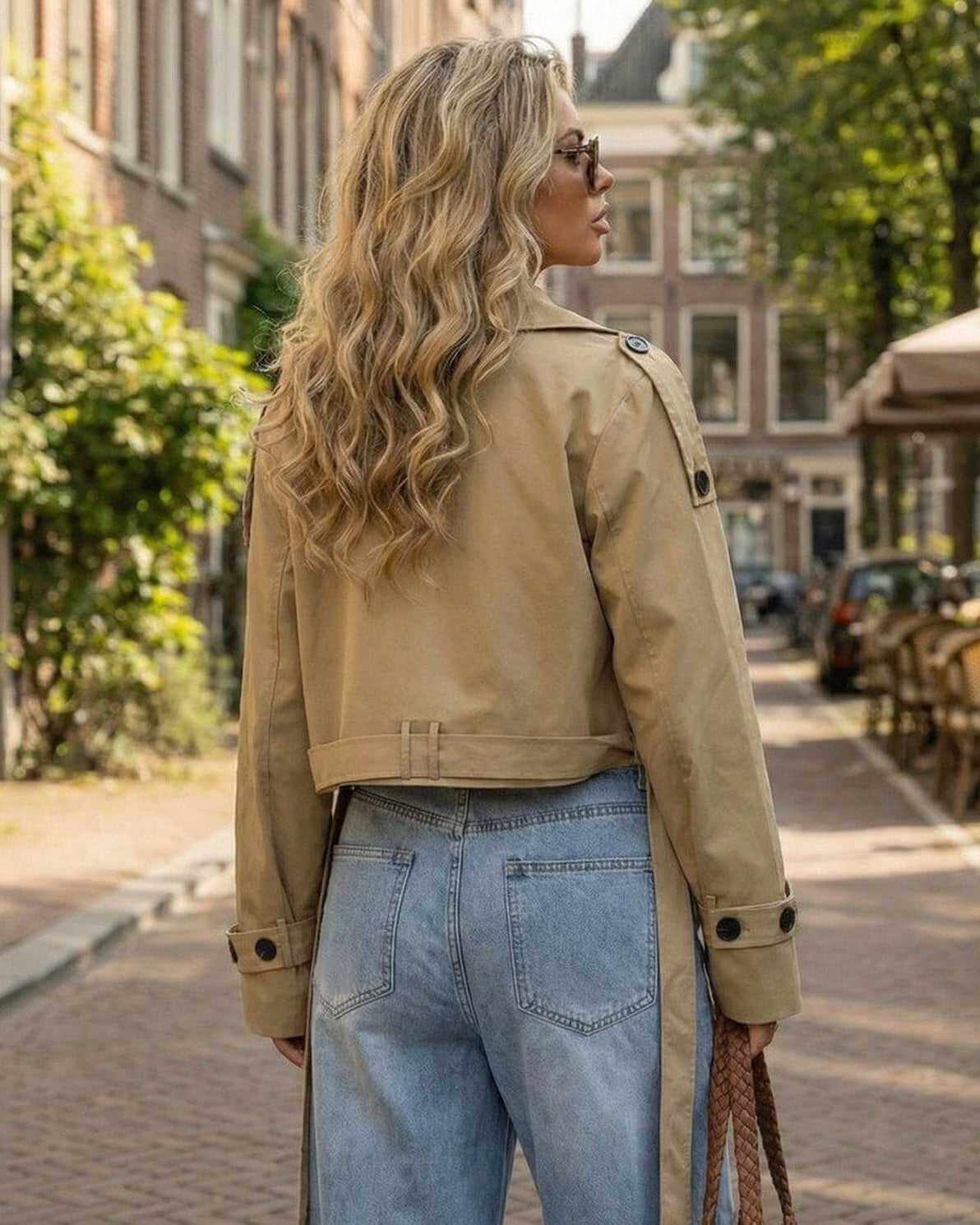 Woman wearing the Monaco Jacket by Lauven, a stylish cropped trench jacket with a belted design.