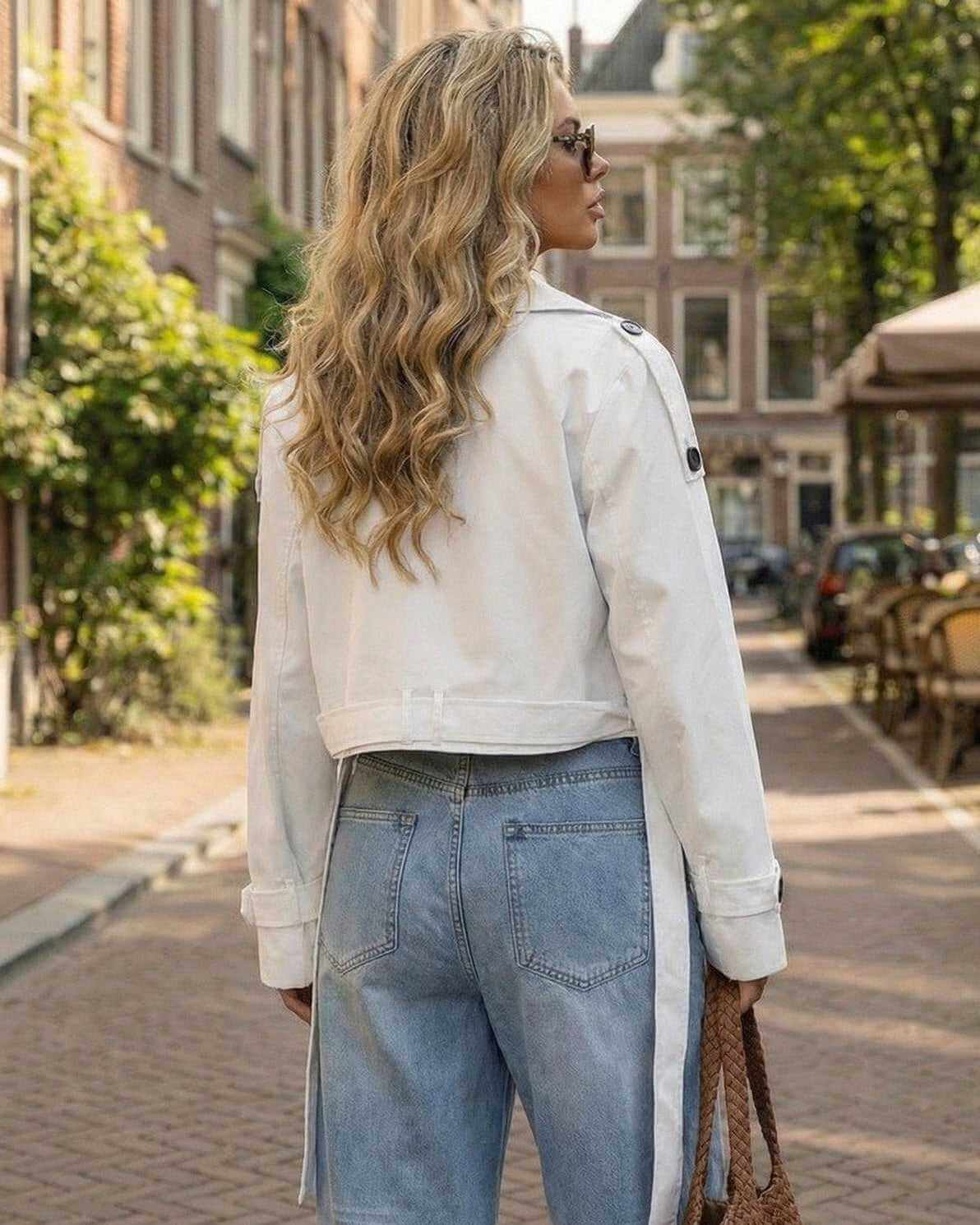 Milano Jacket by Lauven worn by a model outdoors, showcasing a chic white cropped trench design.