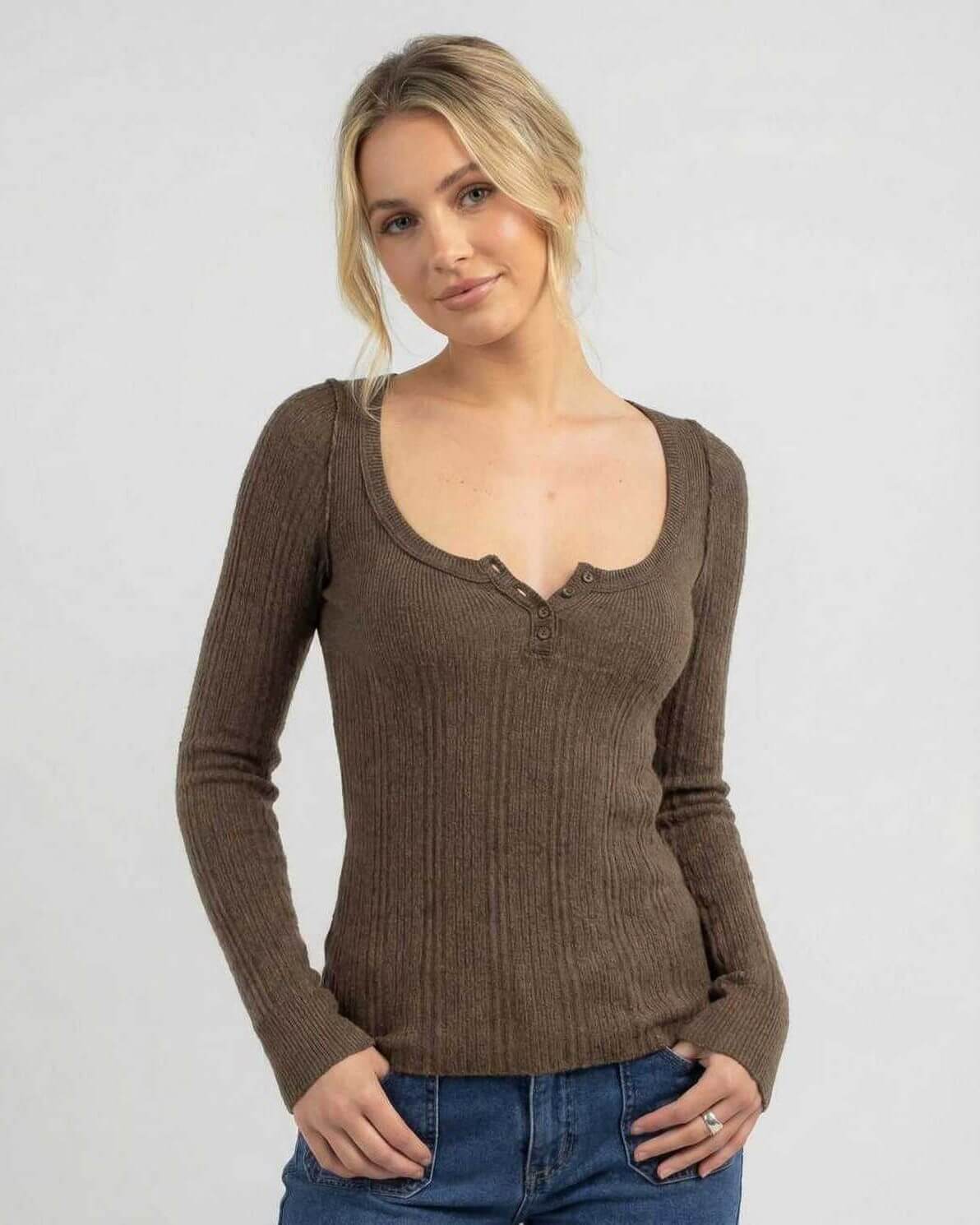 Model wearing the Monaco Long Sleeve, a women's brown ribbed knit shirt with a slim fit and scoop neckline.