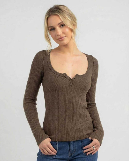 Model wearing the Monaco Long Sleeve, a women's brown ribbed knit shirt with a slim fit and scoop neckline.