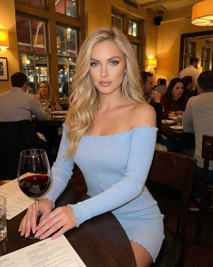 Model wearing Lauven Monaco Mini Dress in light blue, showcasing off the shoulder ribbed knit design in a restaurant setting.