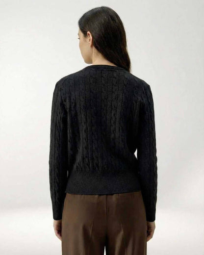 Back view of a woman wearing the Monaco Cardigan, a black cable knit sweater by Lauven.