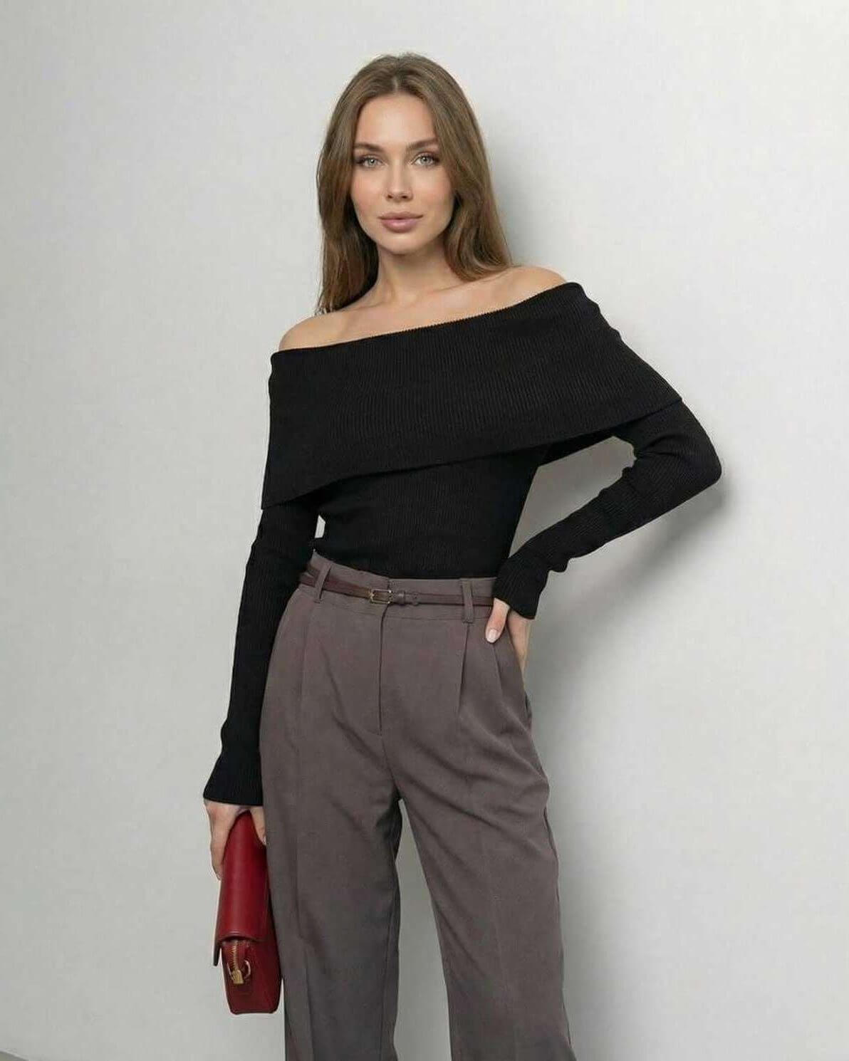 Woman wearing Lauven Monaco Top, an off-the-shoulder long sleeve black top paired with stylish gray pants.
