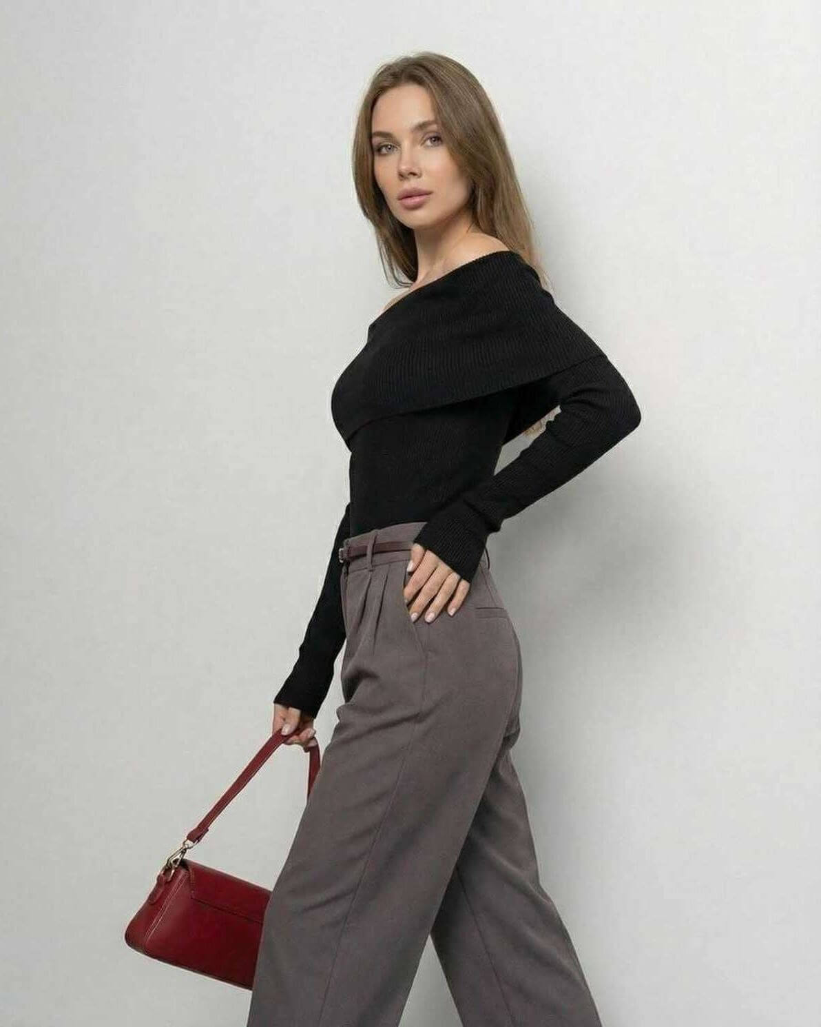 Model wearing Lauven Monaco Top, a women's off-the-shoulder black top, paired with stylish gray trousers.