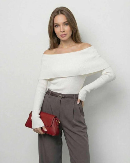 Model wearing the Milano Top by Lauven, an off-the-shoulder long sleeve top in solid white, paired with chic grey trousers.