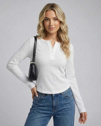 Nara Long Sleeve top by Lauven featuring a woman wearing a white long sleeve round neck design with casual jeans.
