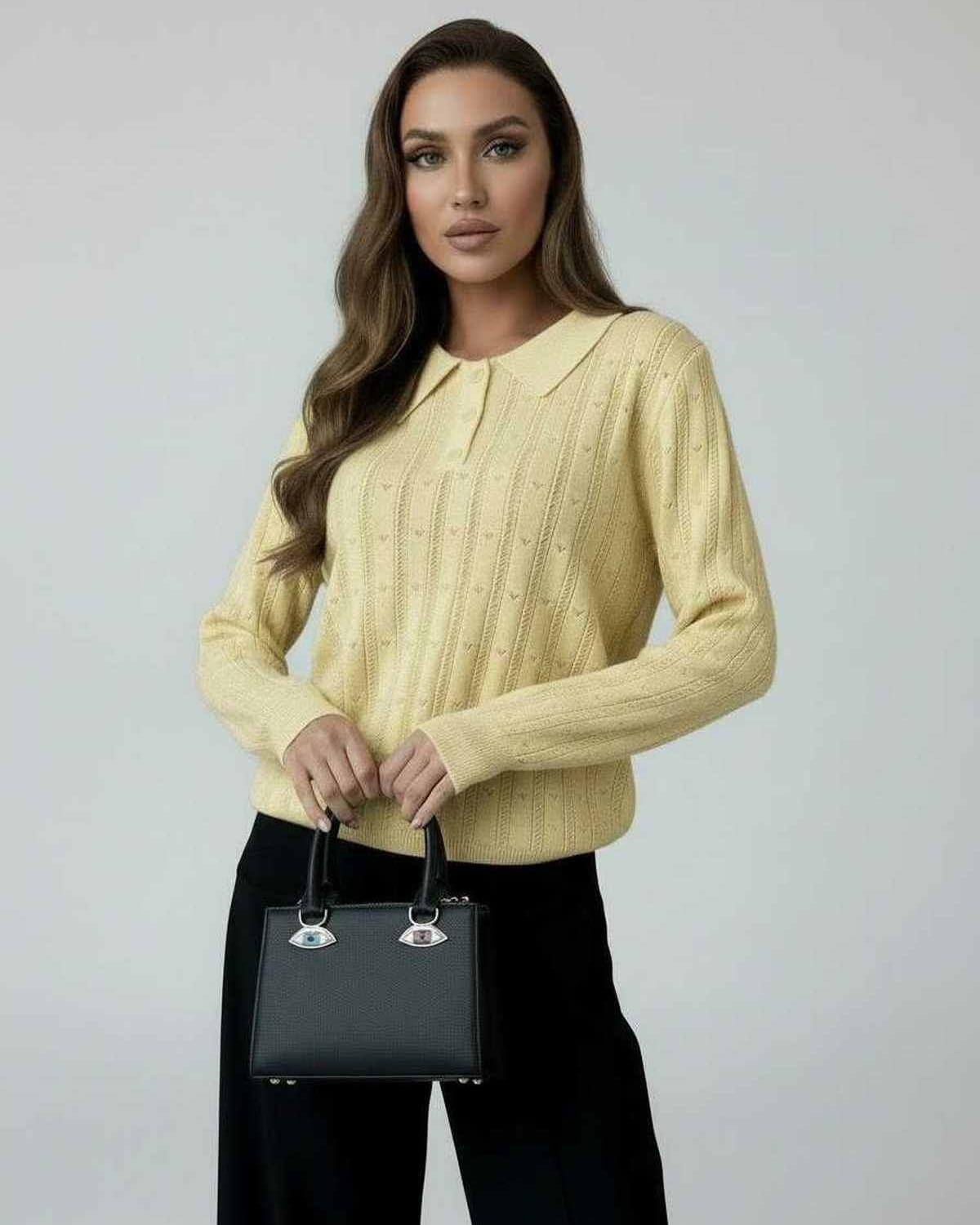 Elegant woman wearing a Lauven Soleil Sweater in yellow with a collared design and holding a black handbag.