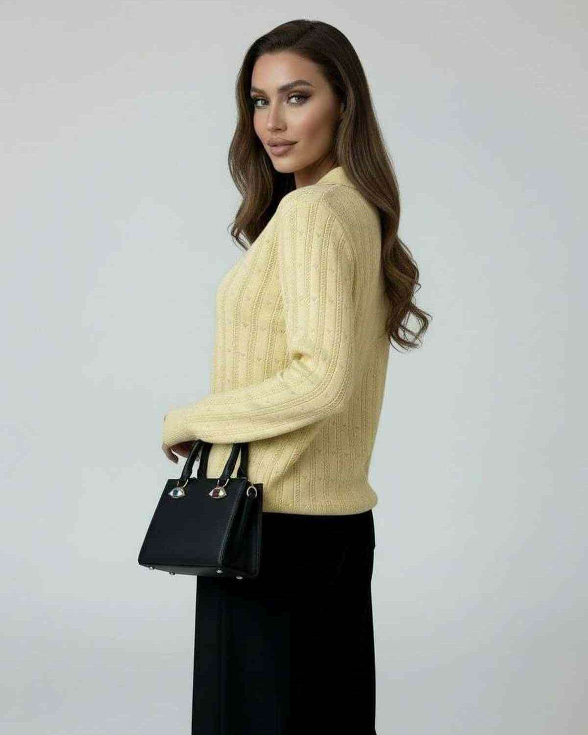 Model wearing the Soleil Sweater by Lauven, a women's yellow knit sweater with long sleeves and a stylish look.