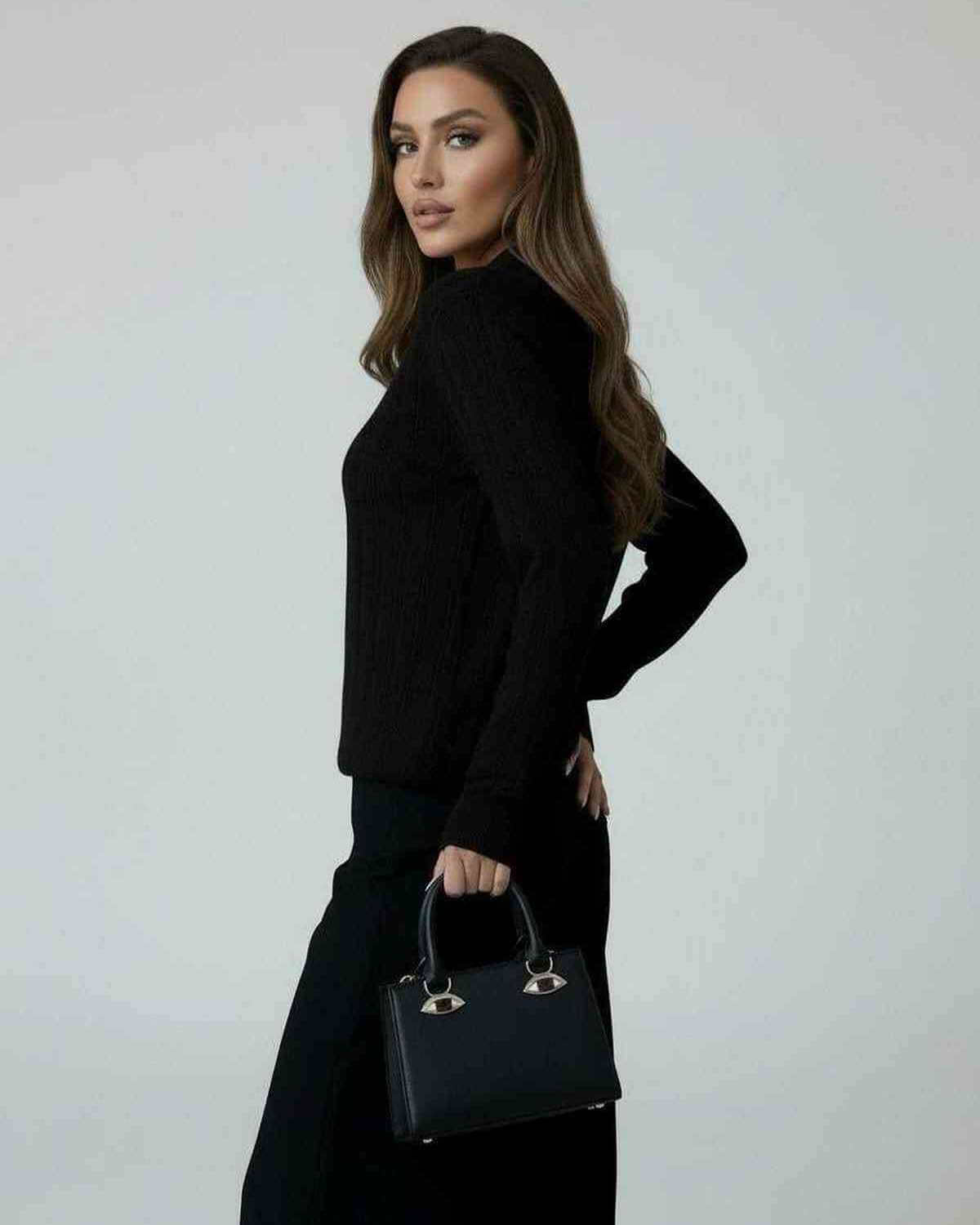 Model wearing the Vega Sweater by Lauven, a women’s black knit sweater with elegant long sleeves.