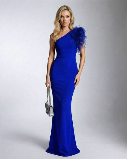 Azura Maxi Dress by Lauven features a one shoulder feather detail and a sleek mermaid silhouette in blue.