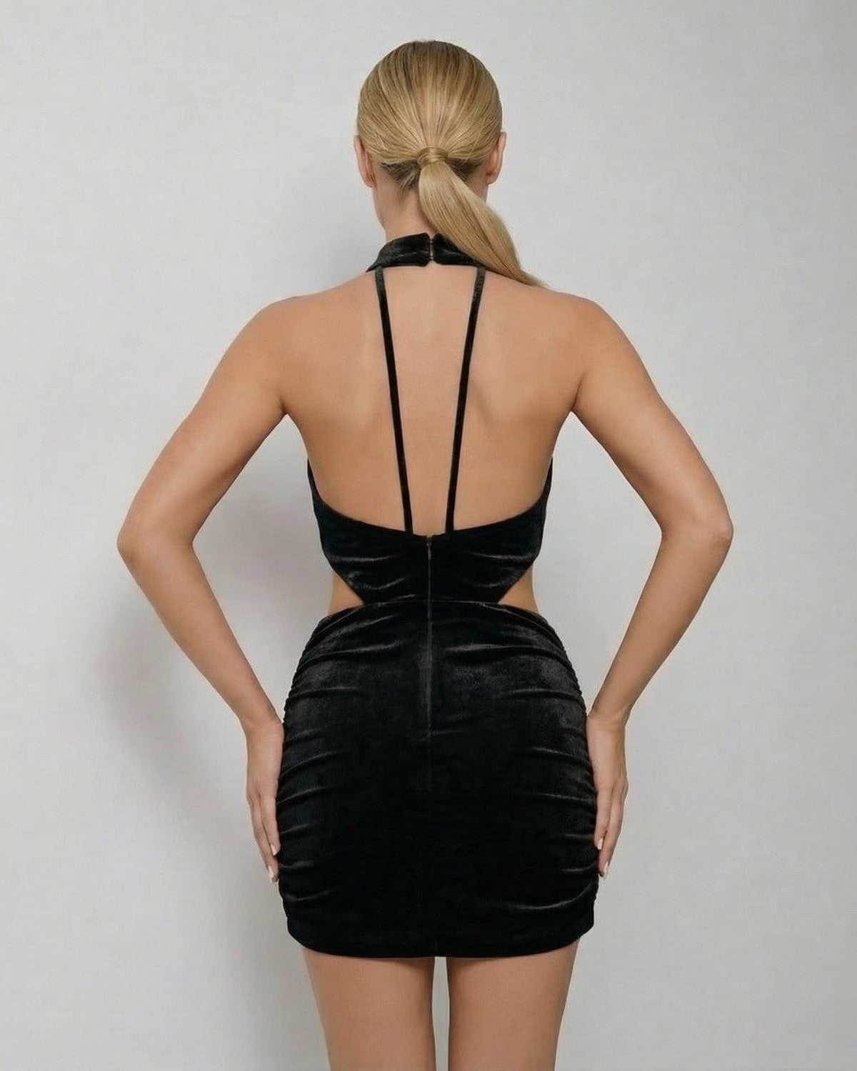 Back view of Lauven Noir Mini Dress showcasing the black velvet bodycon design and sleeveless halter neck style.