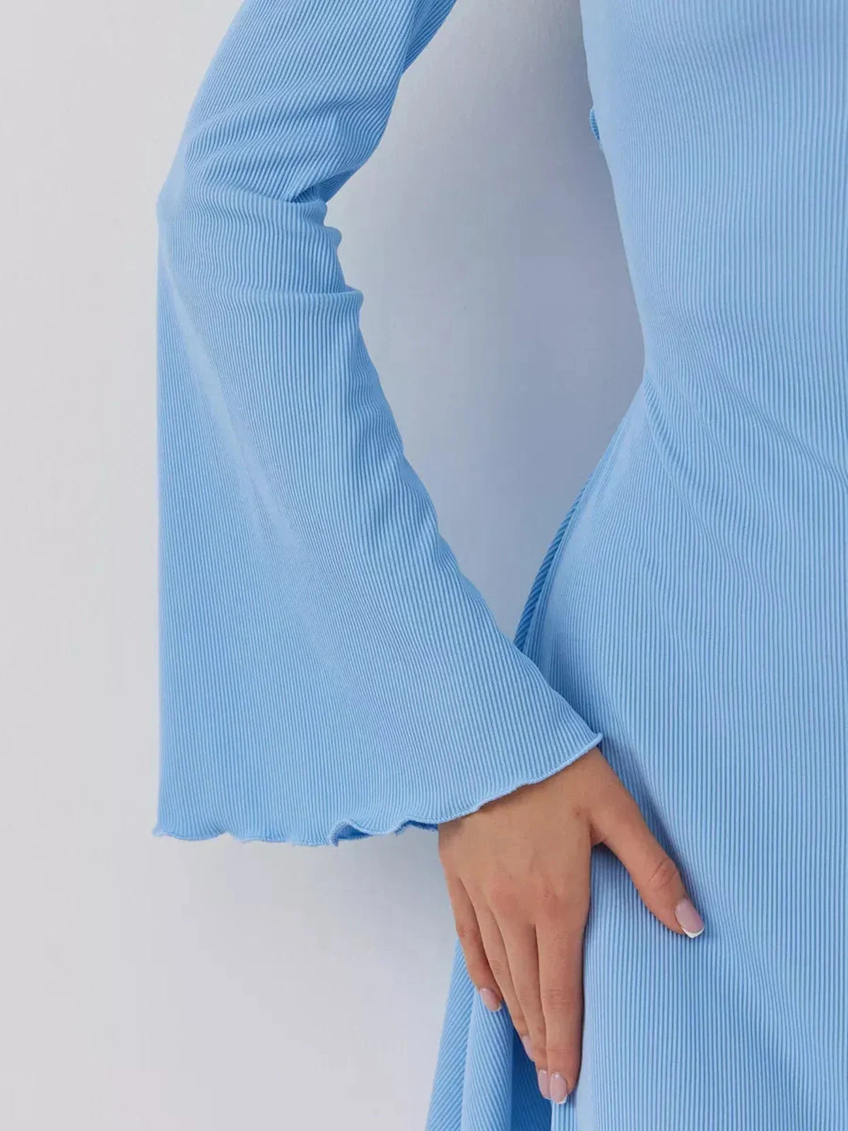 Close-up of the Skyline Cutout mini dress in sky blue, showcasing a ribbed texture and elegant bell sleeves.