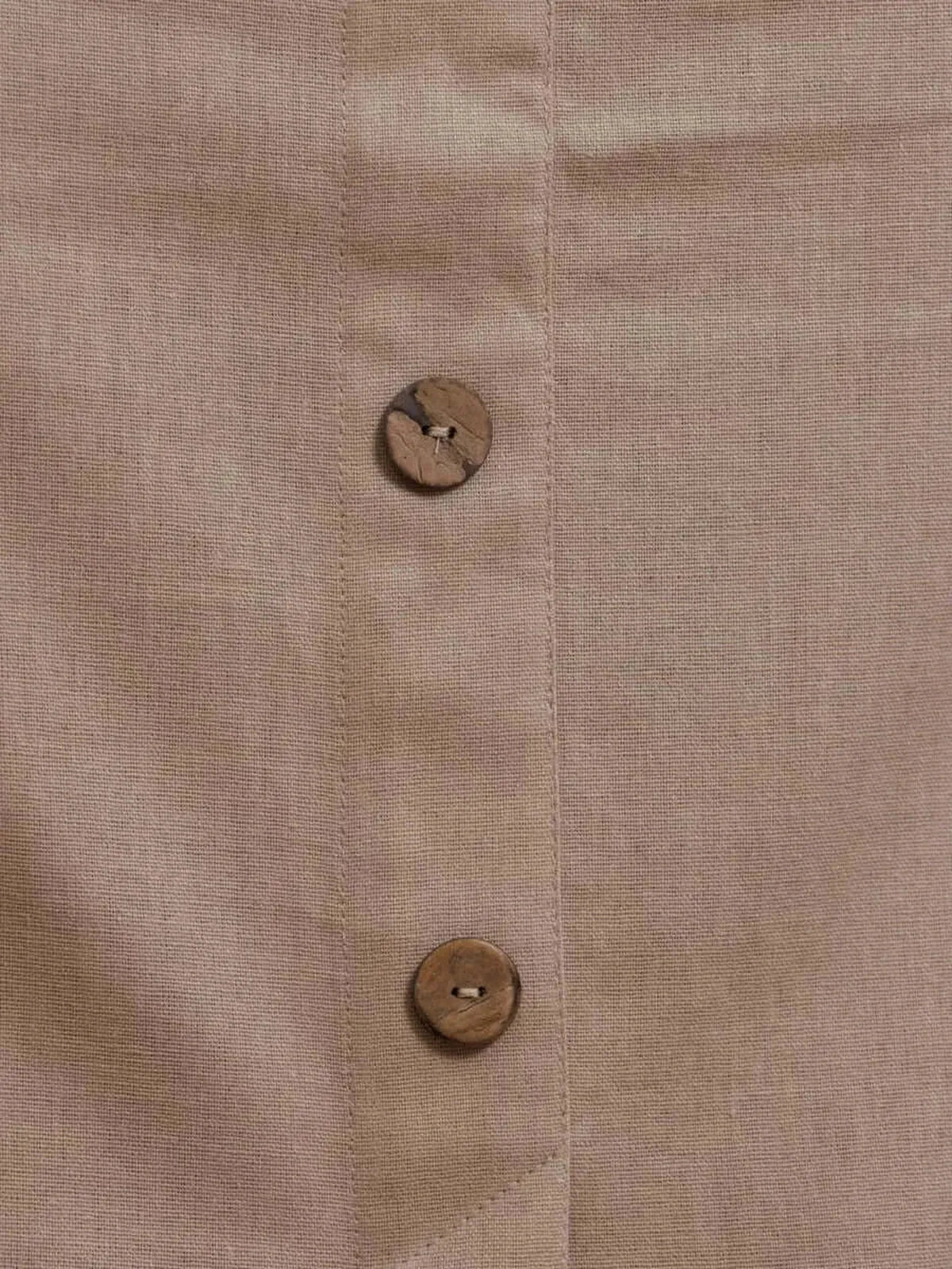 Close-up of Serene Bond Maxi Dress fabric showcasing wooden buttons and soft neutral texture.