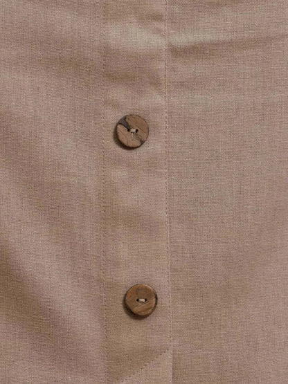 Close-up of Serene Bond Maxi Dress fabric showcasing wooden buttons and soft neutral texture.