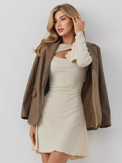 Woman in a cream Sculpted Grace mini dress with a stylish brown blazer, showcasing modern elegance and flair.