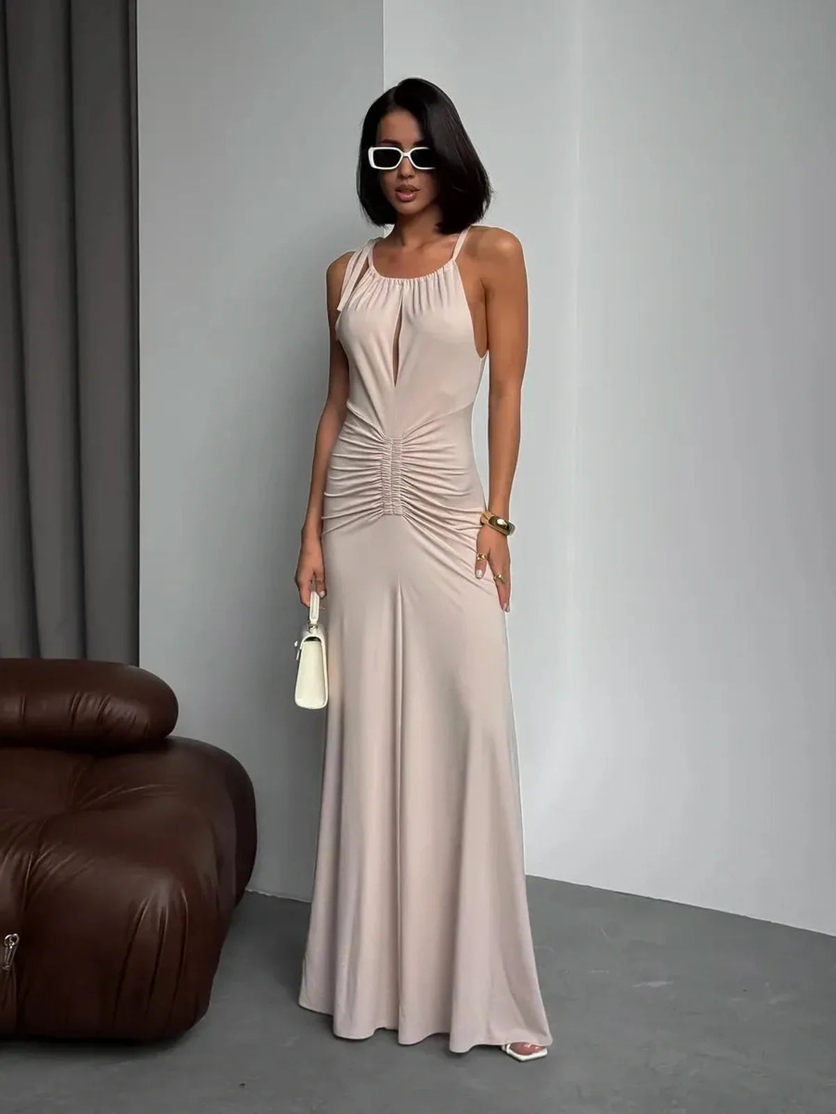 Model wearing Serene Curve Maxi Dress with ruched detailing and halter neckline, showcasing elegant summer style.