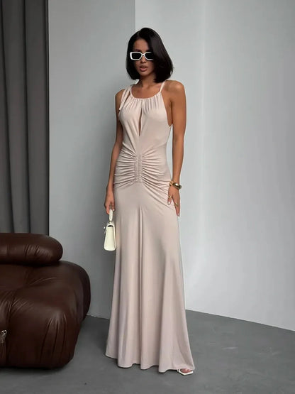 Model wearing Serene Curve Maxi Dress with ruched detailing and halter neckline, showcasing elegant summer style.