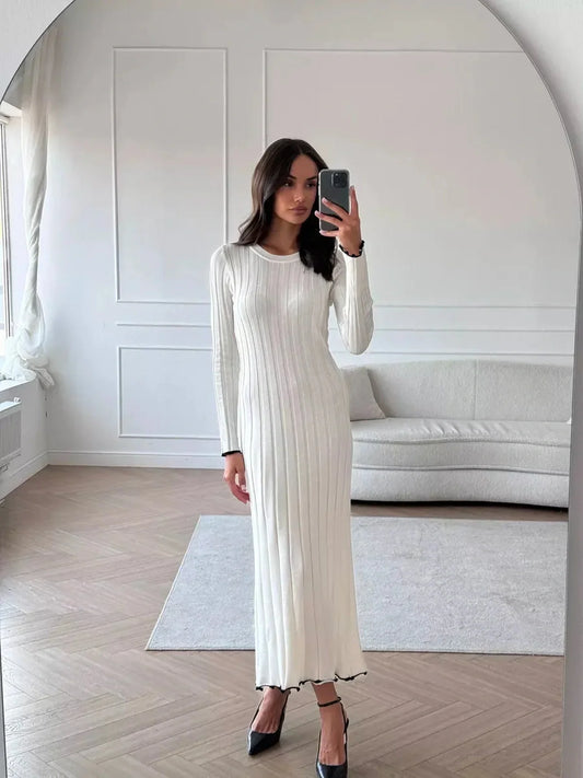 Model wearing the Ivory Grace Maxi Dress, showcasing its elegant ribbed texture and delicate ruffle trim.