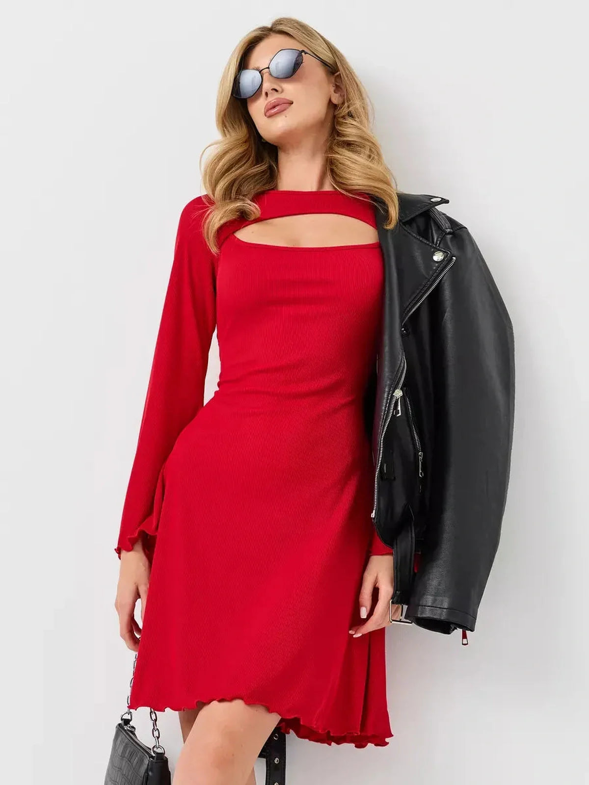 Stylish woman in a red flare cutout mini dress, wearing sunglasses and a leather jacket, exuding modern flair.