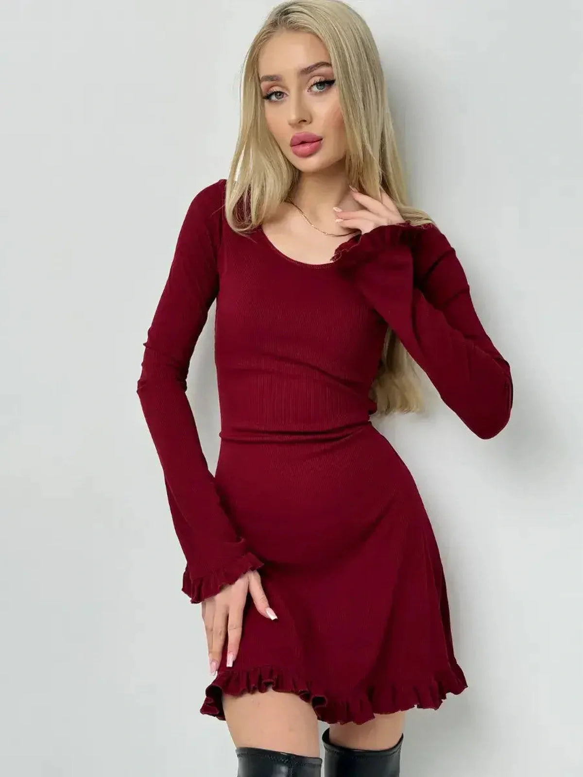 Model showcasing the Crimson Flare ribbed knit red dress with romantic ruffles and a fitted silhouette.