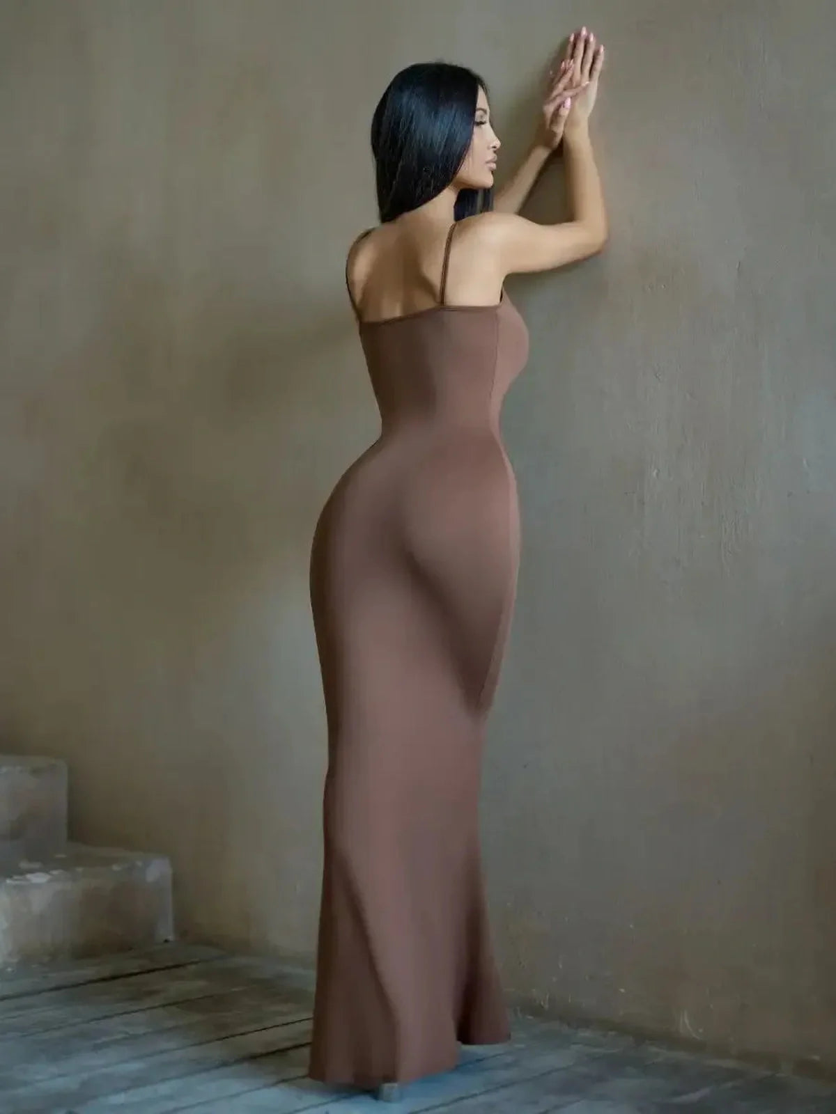 Model wearing Cocoa Curve Maxi Dress in rich chocolate hue, showcasing elegant silhouette and minimalistic design.