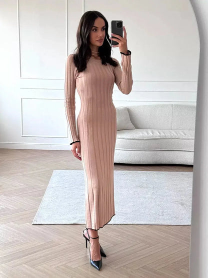 Model wearing Sahara Curve Maxi Dress in sandstone beige, showcasing its soft ribbed texture and elegant full-length cut.