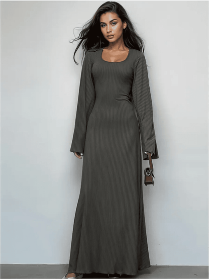 Elegant granite luxe maxi dress with a sculpting fit and flared sleeves, perfect for day-to-dusk styling.