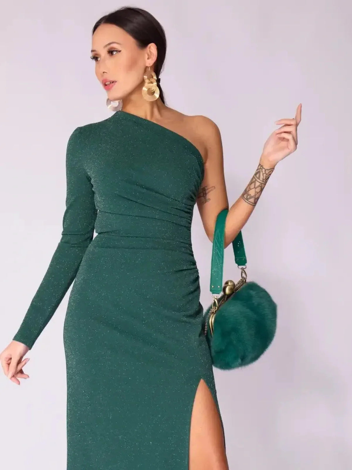 Model wearing the Emerald Spark Maxi Dress, showcasing a one-shoulder design and high side slit in shimmering green.