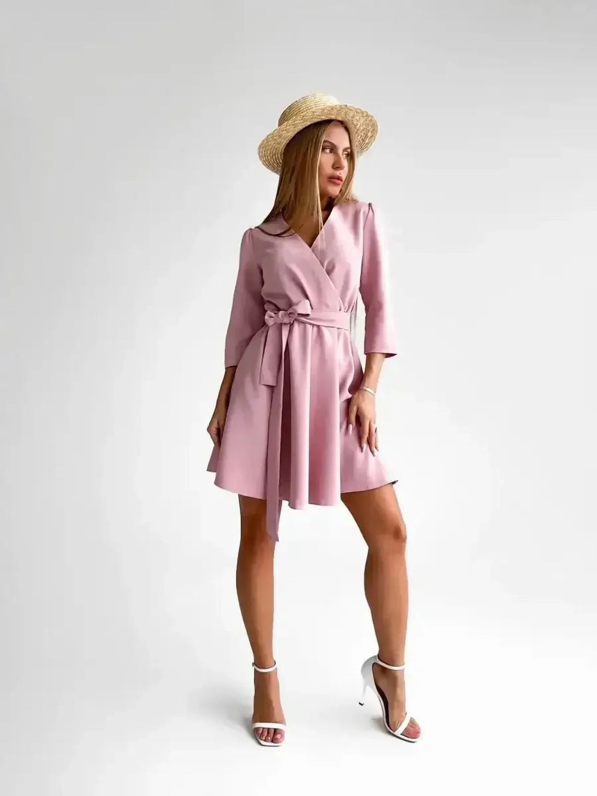 Elegant woman in a pink mini dress with a belt and straw hat, showcasing the Rosé Flair style.