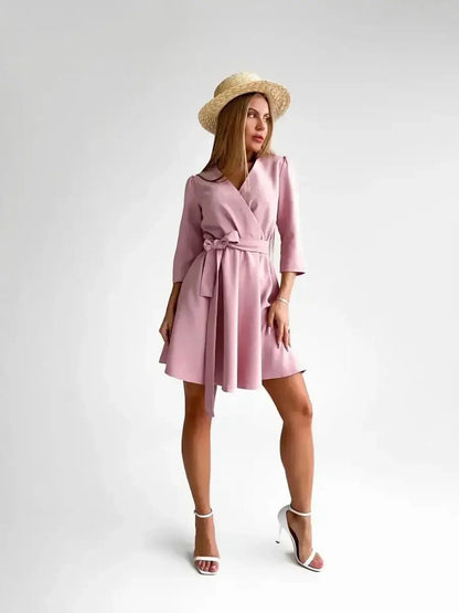 Elegant woman in a pink mini dress with a belt and straw hat, showcasing the Rosé Flair style.