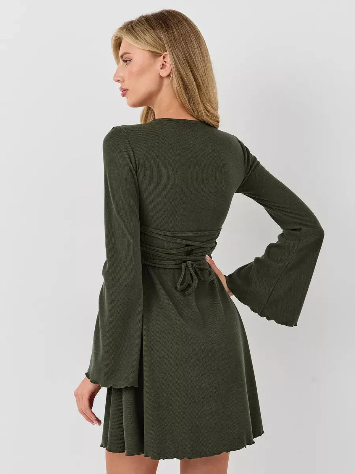 Back view of a woman wearing the Ivy Bell mini dress with flared bell sleeves and a cinched waist.