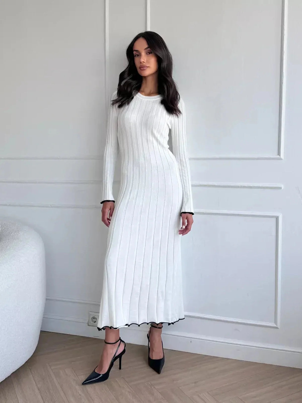 Model wearing the Ivory Grace Maxi Dress, showcasing elegant ribbed texture and ruffle trim in a chic setting.