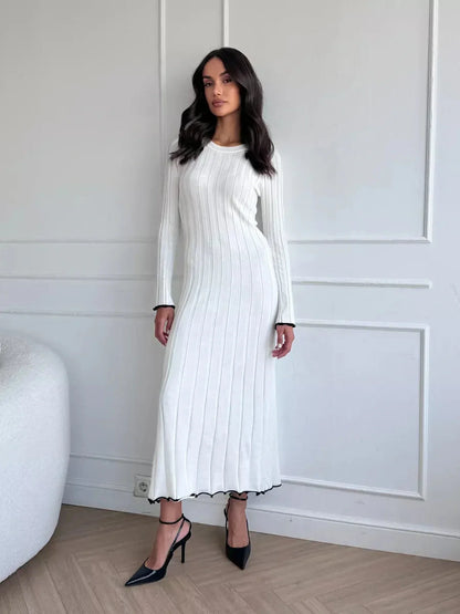 Model wearing the Ivory Grace Maxi Dress, showcasing elegant ribbed texture and ruffle trim in a chic setting.