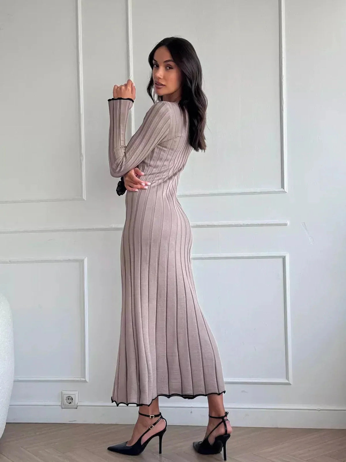 Model showcasing the Contour Maxi Dress in ribbed knit with a ruffle hem, highlighting its elegant silhouette.