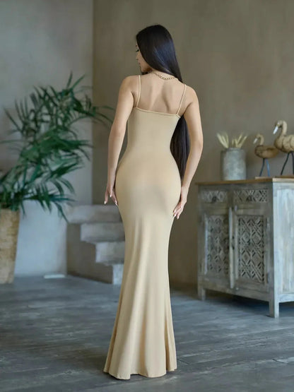 Back view of a model in a sleek, body-hugging Sculpted Elegance Maxi Dress in a minimalist, stylish setting.