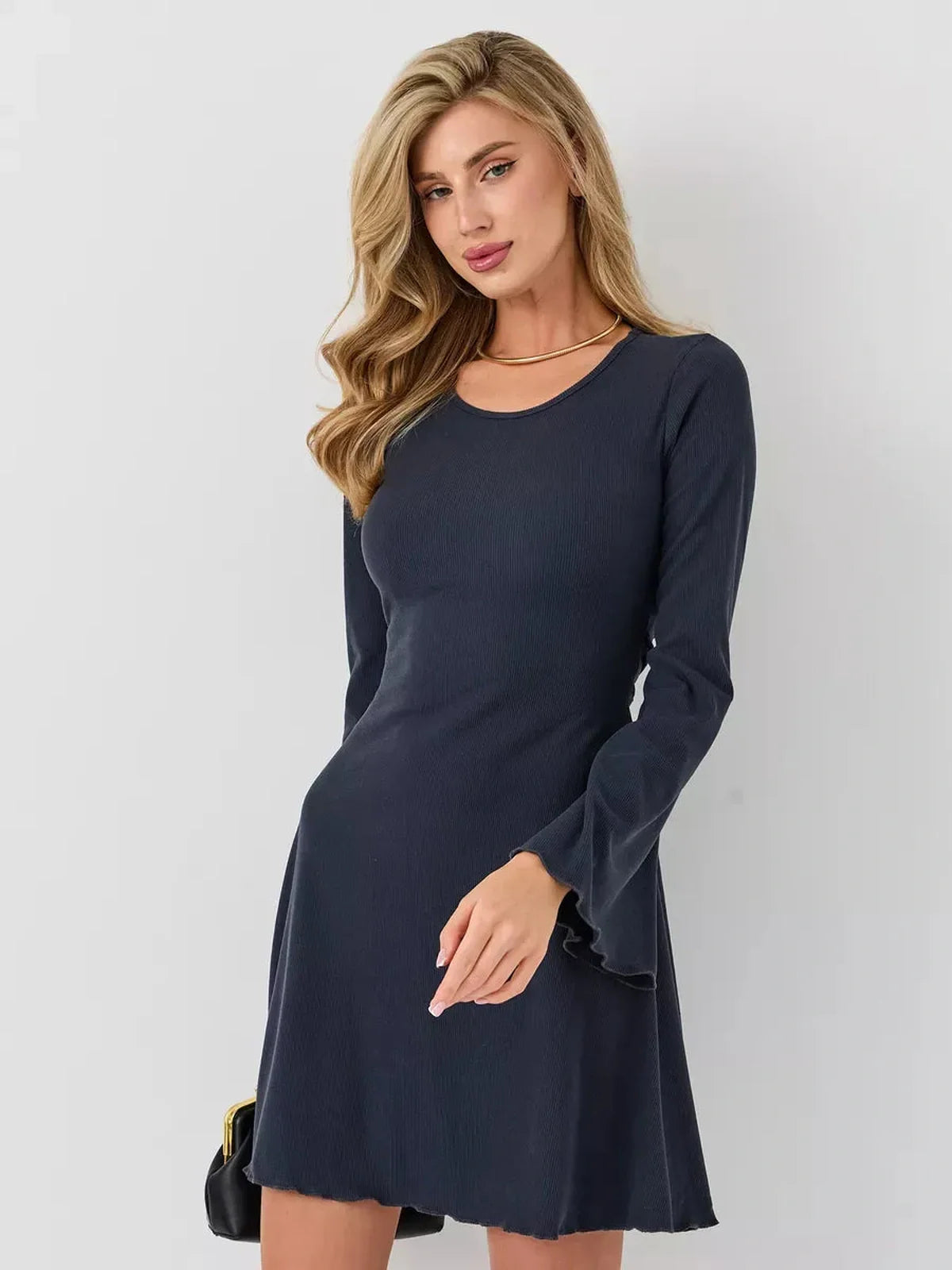 Model wearing a stylish navy Graphite Grace mini dress with long sleeves and a flared hemline.