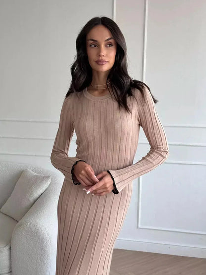 Woman showcasing the Sahara Curve Maxi Dress in sandstone beige with soft ribbed texture and elegant silhouette.