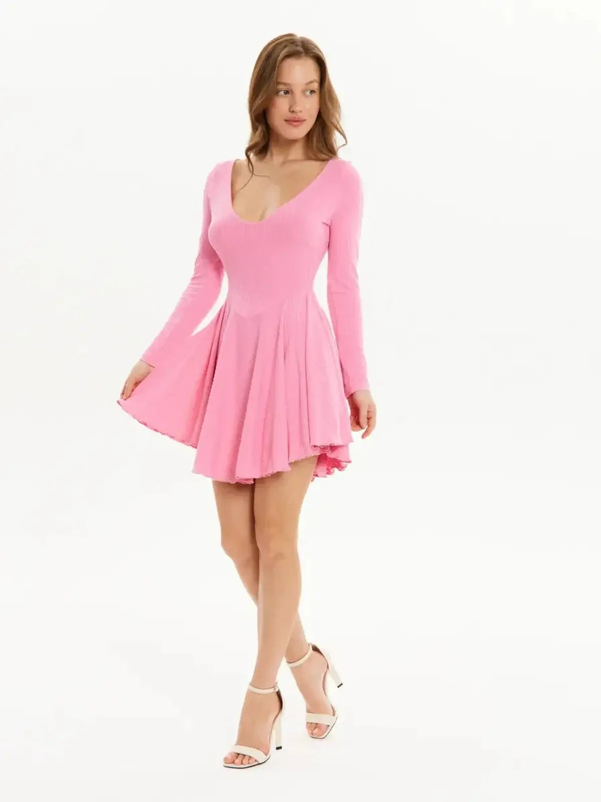 Playful pink mini dress with flared skirt and long sleeves, perfect for summer and wedding guest occasions.
