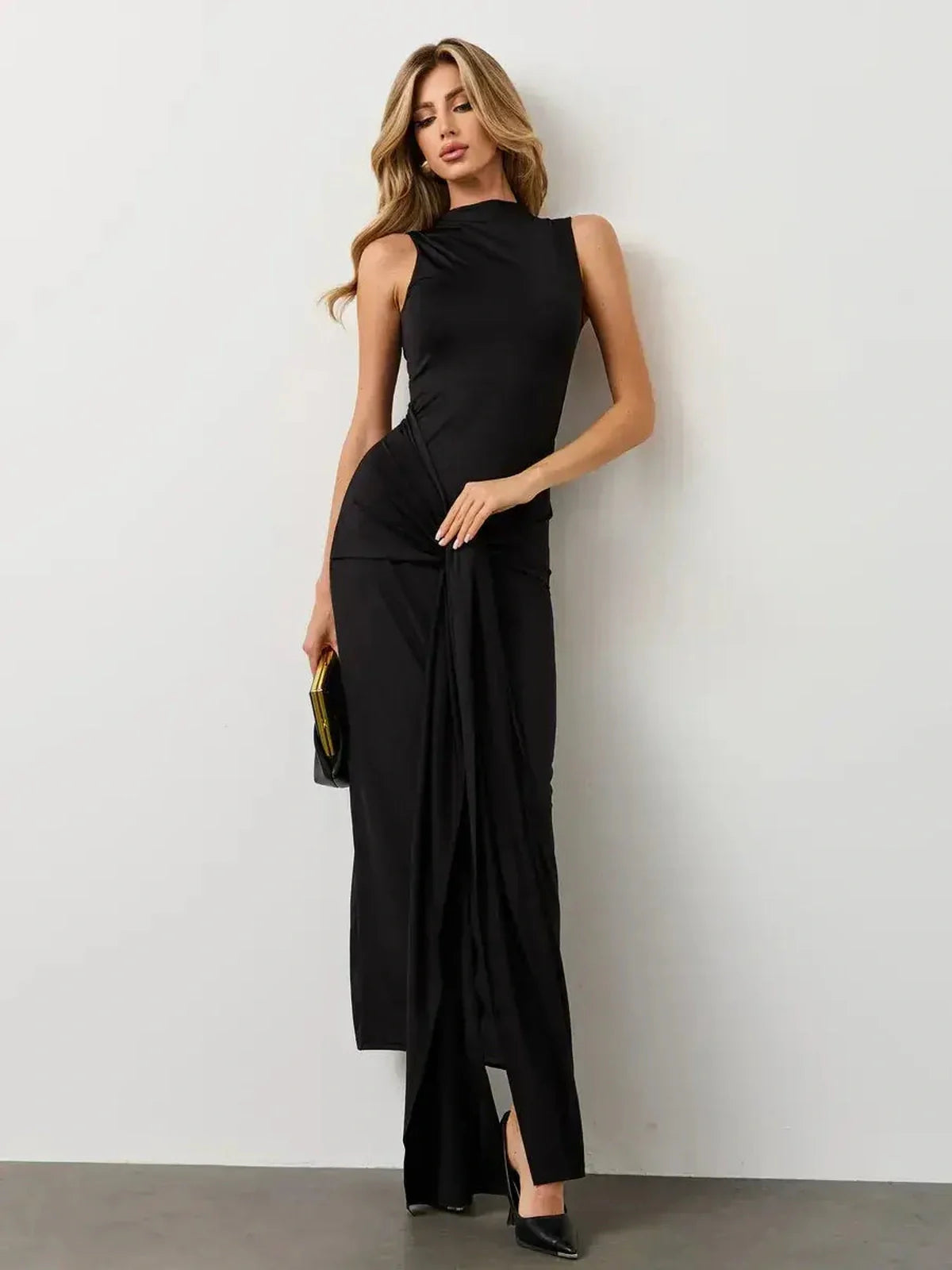 Elegant woman in an Obsidian Drape Maxi Dress, showcasing sculpted silhouette and dramatic knot detail.