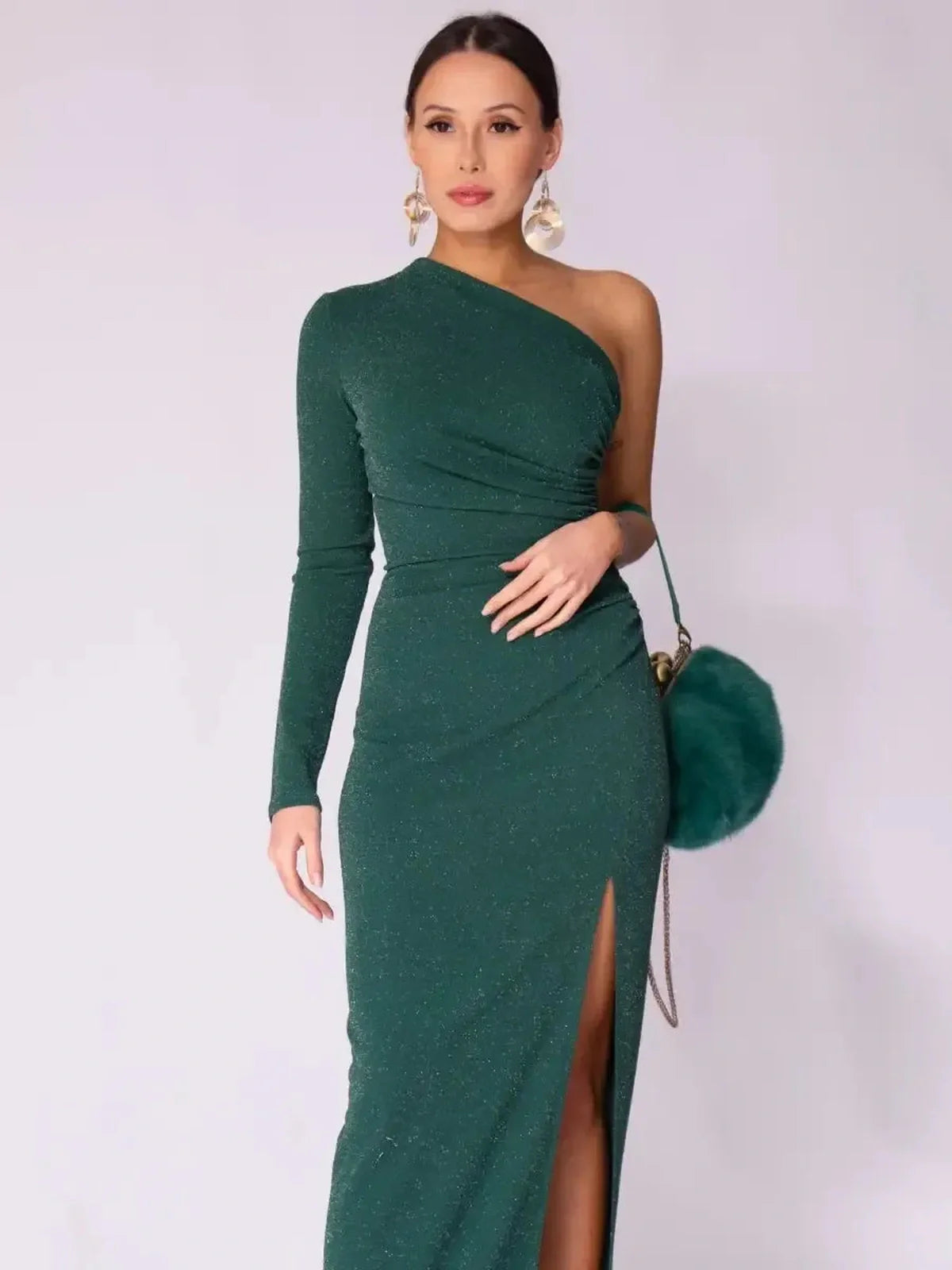 Emerald Spark Maxi Dress in rich green with one-shoulder design and high side slit, showcasing modern elegance and shimmer.