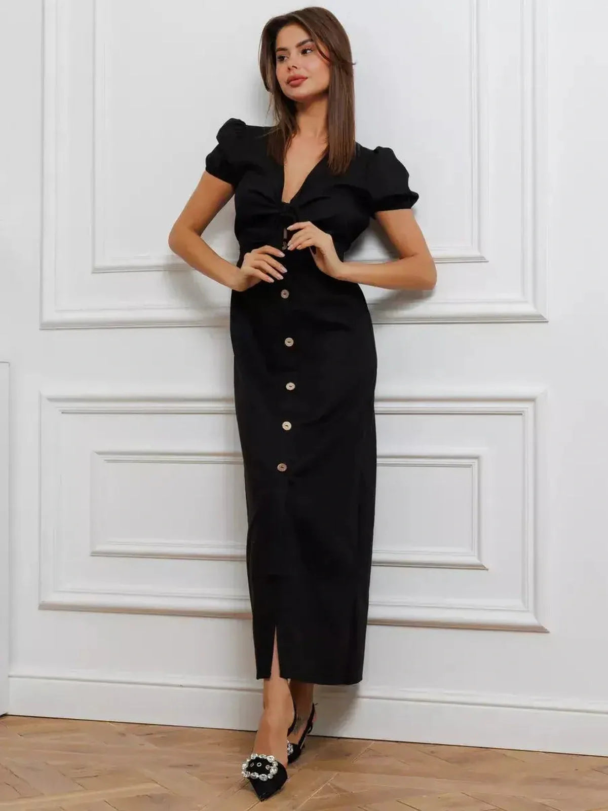 Elegant black maxi dress with tie-front detail, puff sleeves, and button accents, perfect for stylish occasions.
