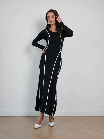 Model wearing the Midnight Curve Maxi Dress in black, featuring elegant white piping and a flattering silhouette.