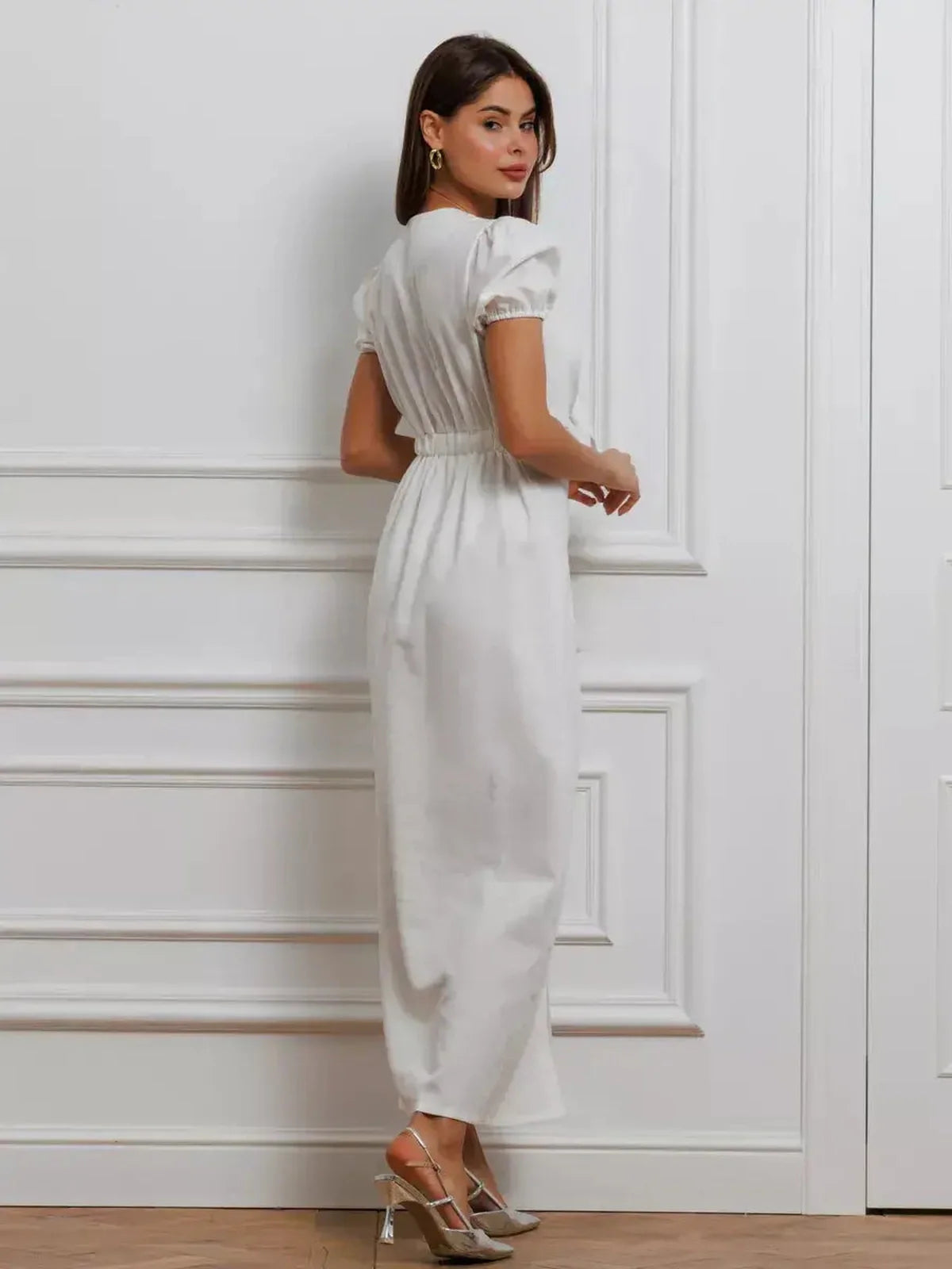 Elegant white maxi dress with puff sleeves and a cinched waist, showcasing a minimalist design and romantic flair.