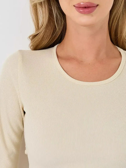 Close-up of a woman wearing an ivory ribbed long sleeve dress, showcasing its elegant neckline and texture.