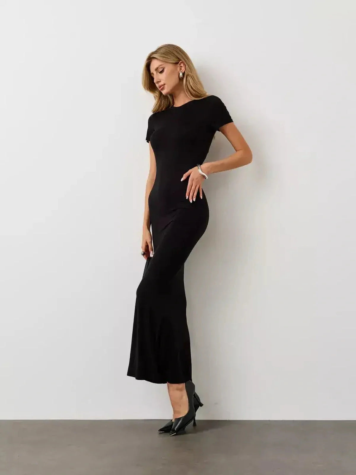 Model wearing the Noir Curve Maxi Dress in black, showcasing its sculpted silhouette and elegant flared hem.